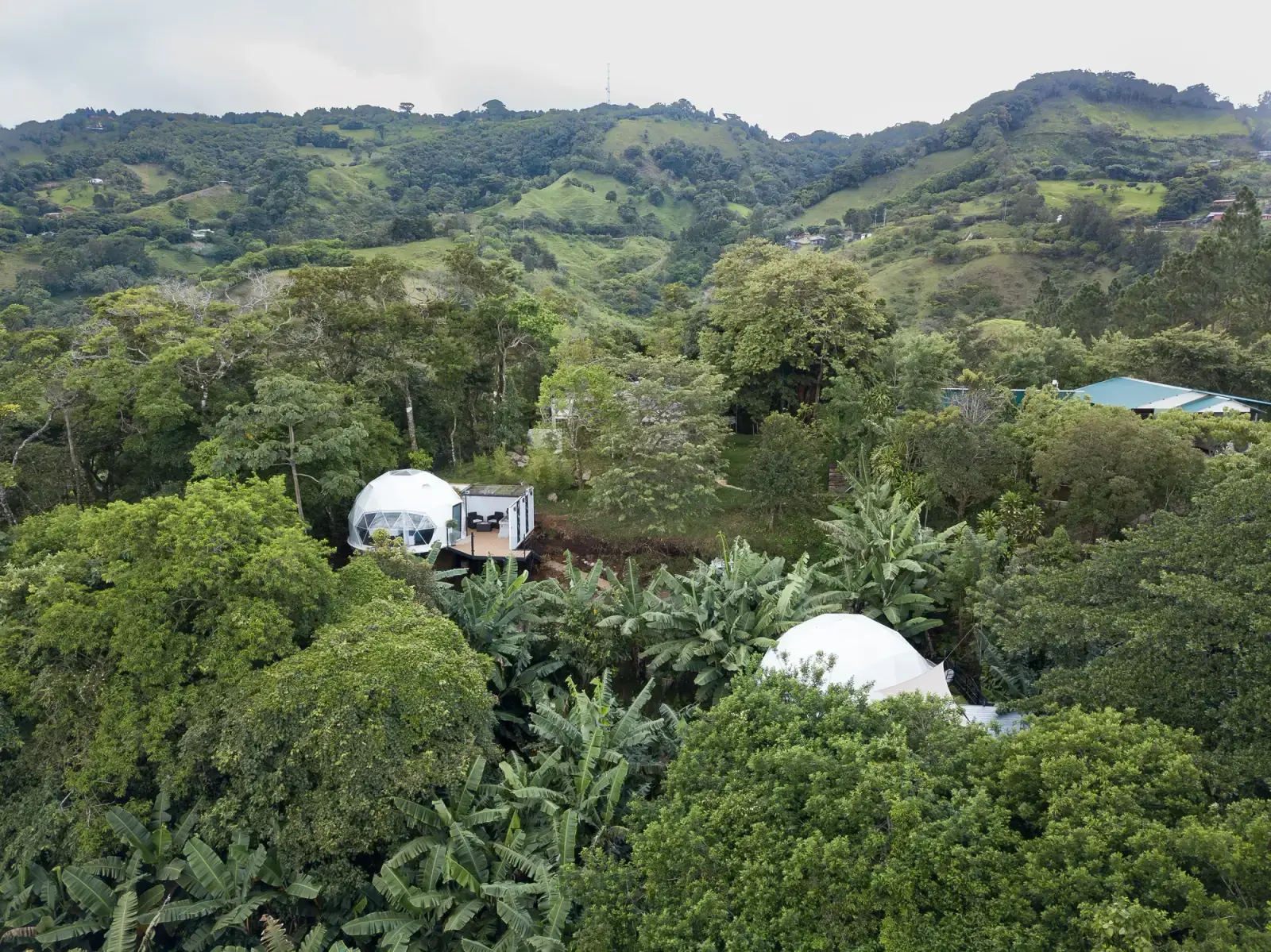 Domos de Macas Moon rodeados de vegetación y las montañas de Monteverde
